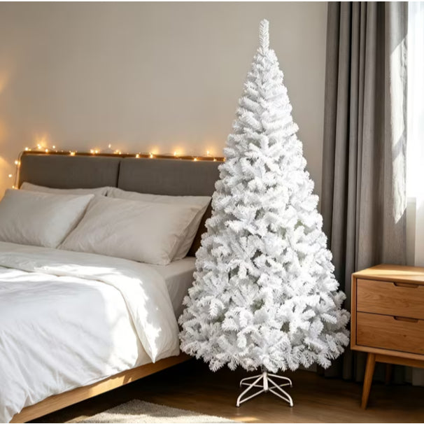 Árvore de Natal branca Boreal com base de ferro ao lado da cama em um quarto com luzes de fio