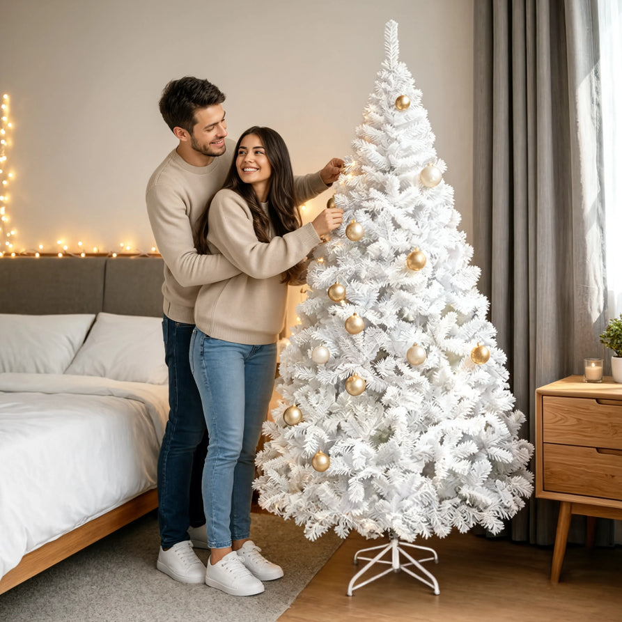 Casal enfeitando a árvore de Natal branca Boreal com bolas douradas em um quarto