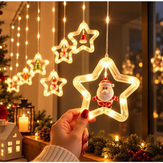 Mão segurando uma estrela iluminada com Papai Noel da cortina de LED Cascalis modelo Estrela, ao lado de uma janela